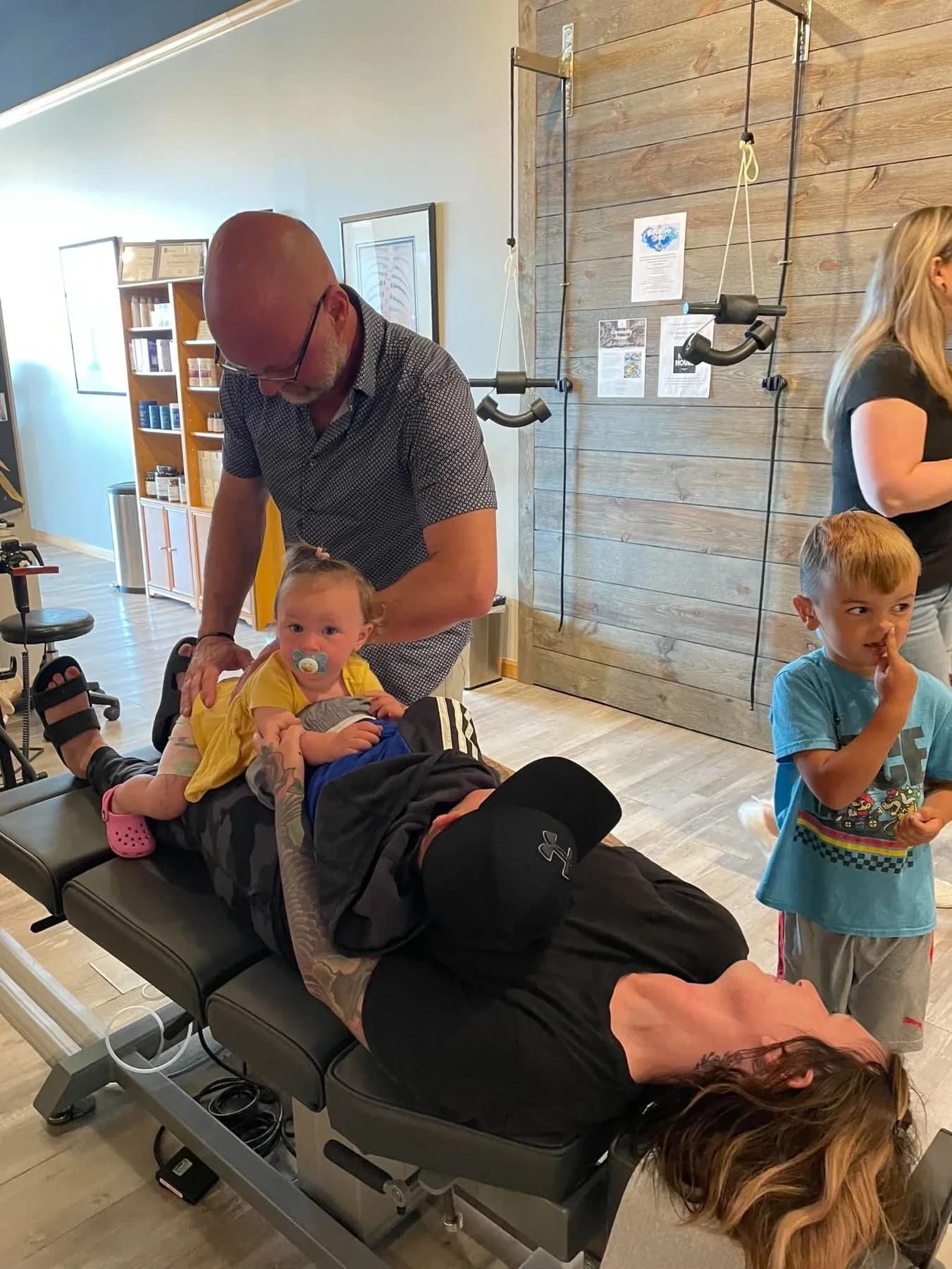 Dr. Ed McCuiston adjusting a parent while children are nearby