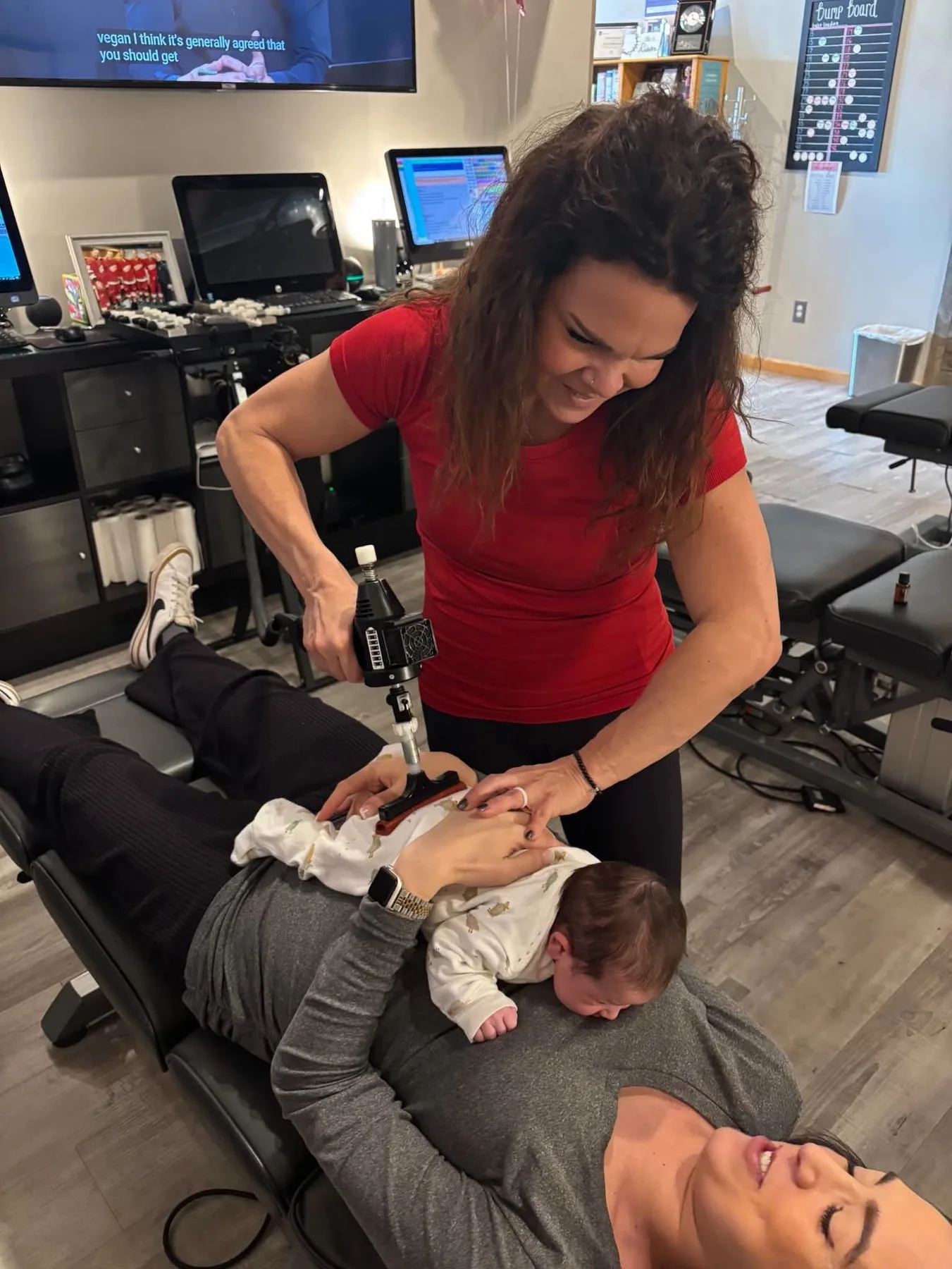 Dr. Sandie McCuiston gently adjusting a baby while the mother holds the baby