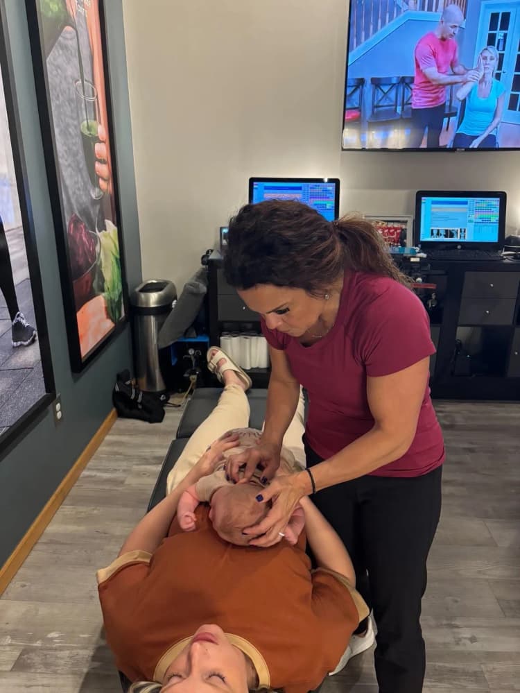 Dr. Sandie McCuiston adjusting a child — supervising detox programs as part of the MaxLiving 5 Essentials